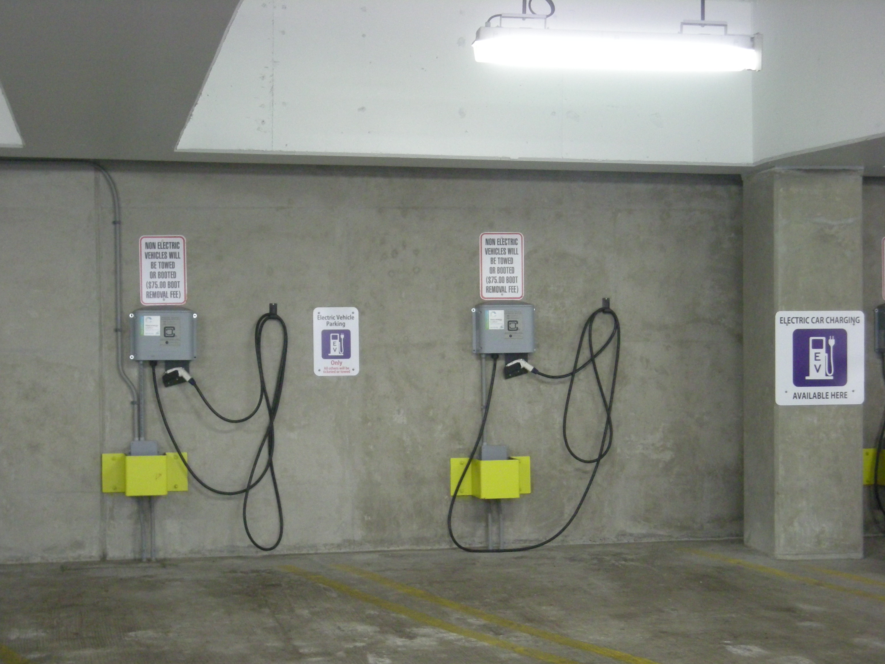 A row of EV charging stations at a parking structure