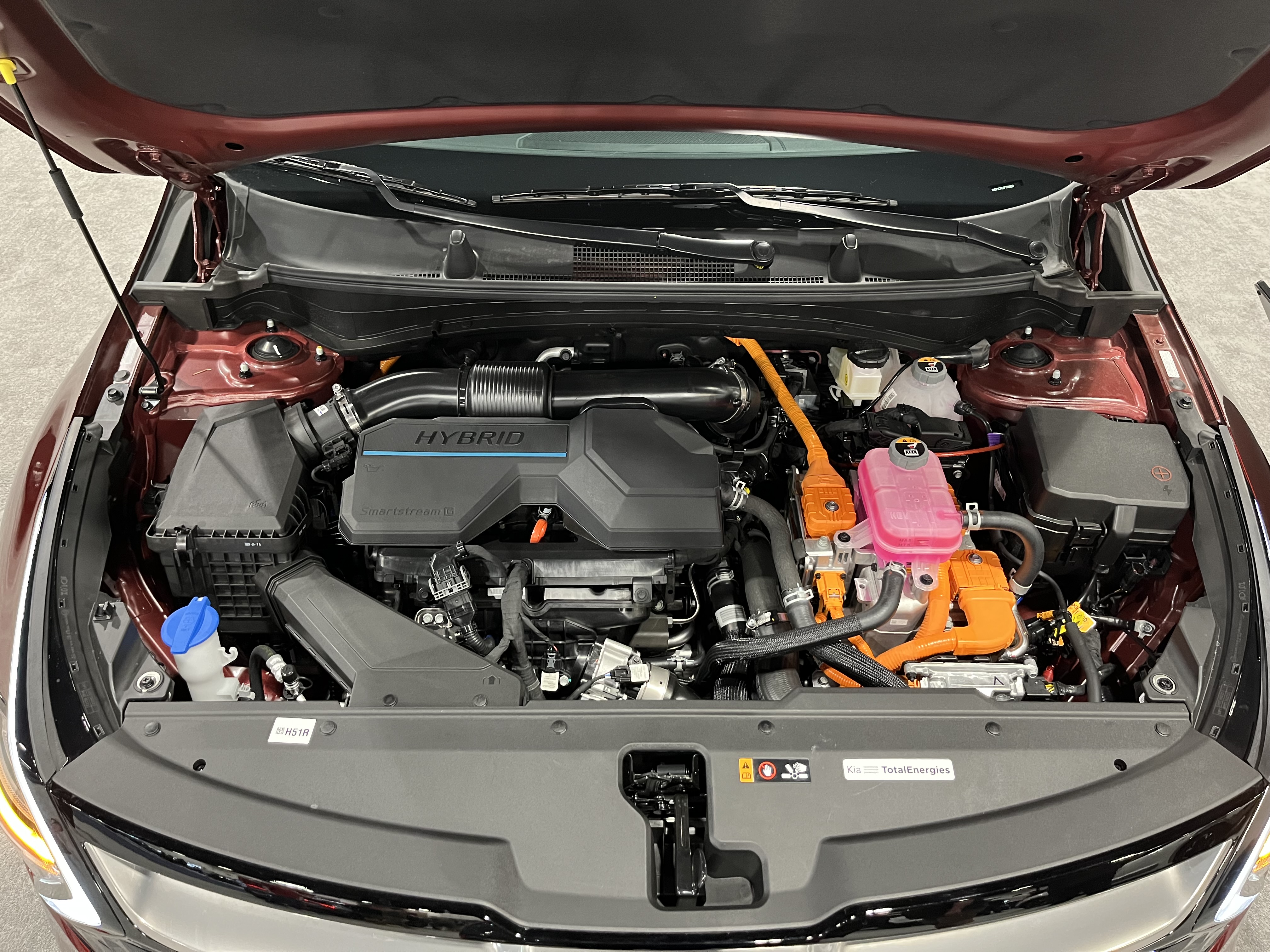 Under-hood engine bay of a hybrid SUV showing powertrain components